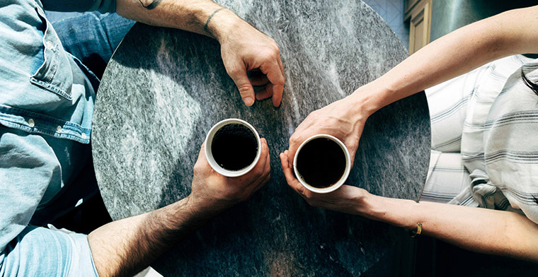 couple across table from each other having coffee