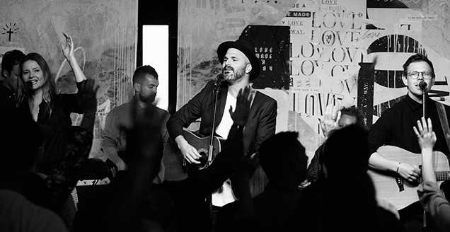 Greg (centre) leads worship in Sydney.