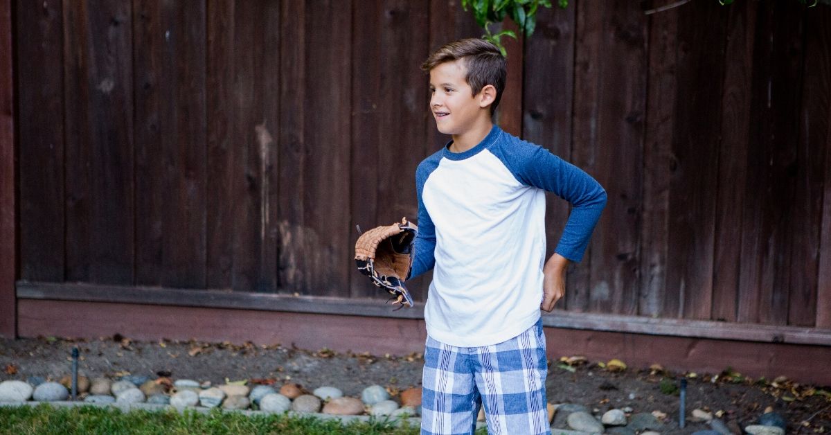 a boy playing softball in the backyard