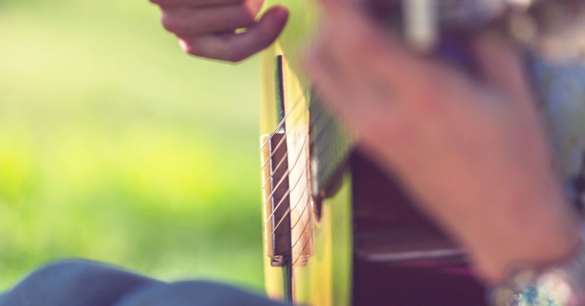 photo a guitar being strummed up close