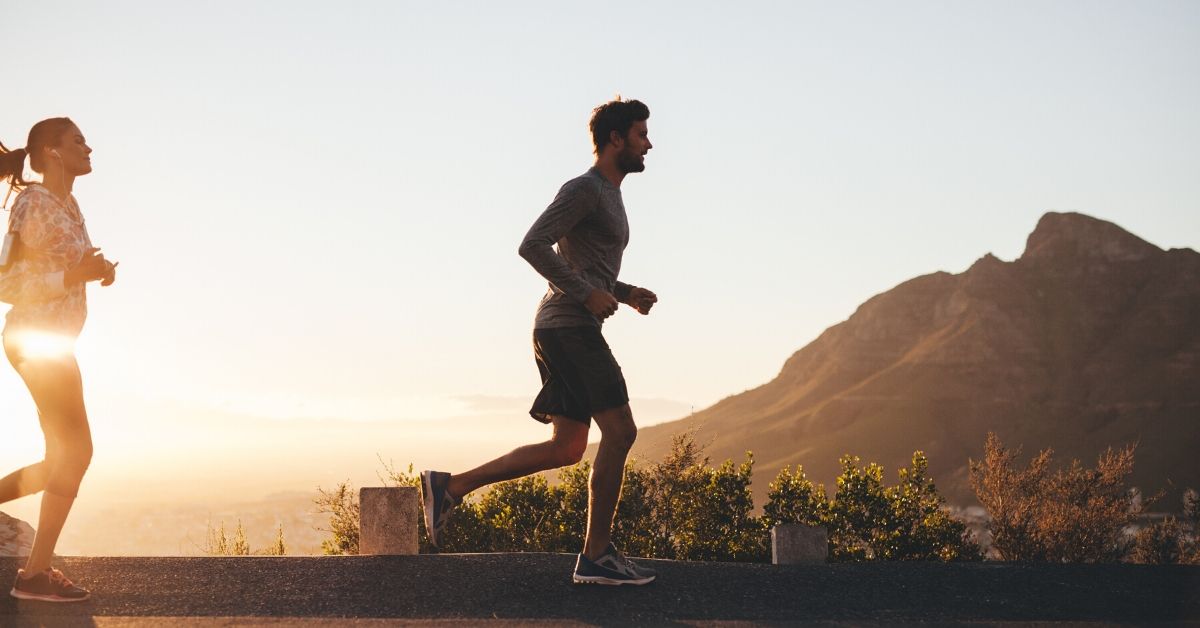 photo of a man and woman running at sunrise