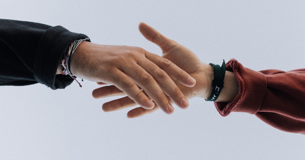 close up photo of a hand reaching for another hand